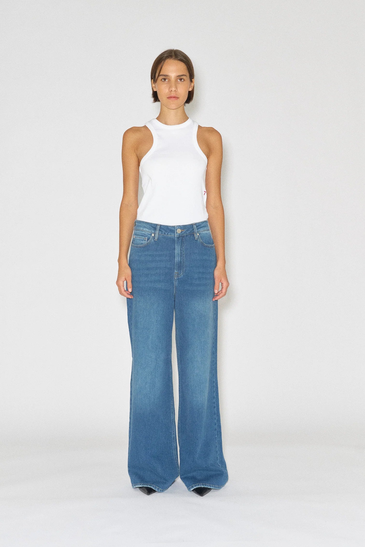 Model wears wide, straight leg jeans in mid blue