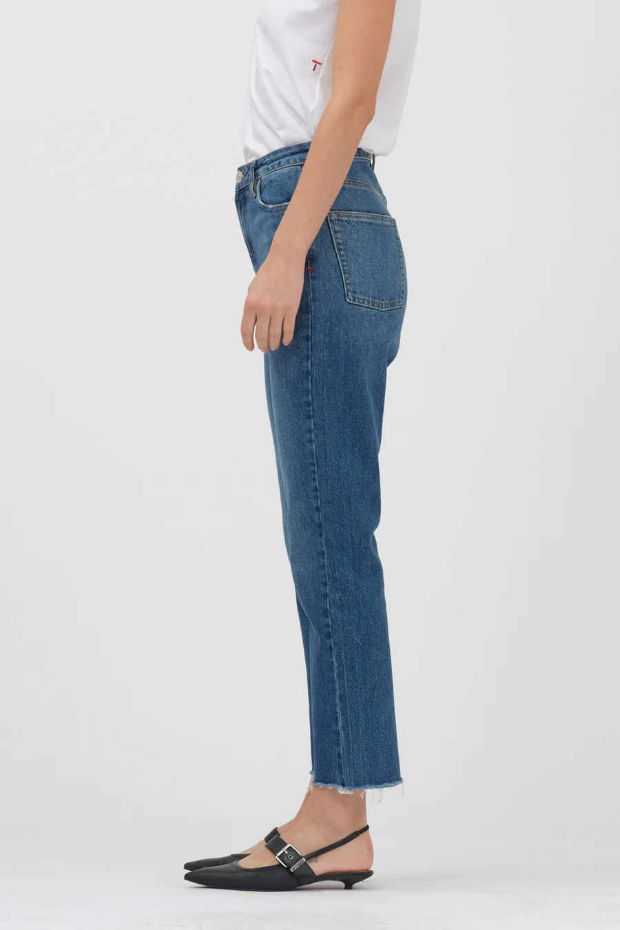 The back view of a woman wearing Tomorrow Denim's Anne Slim Jeans - Boston, a high waist white t-shirt made from organic cotton.
