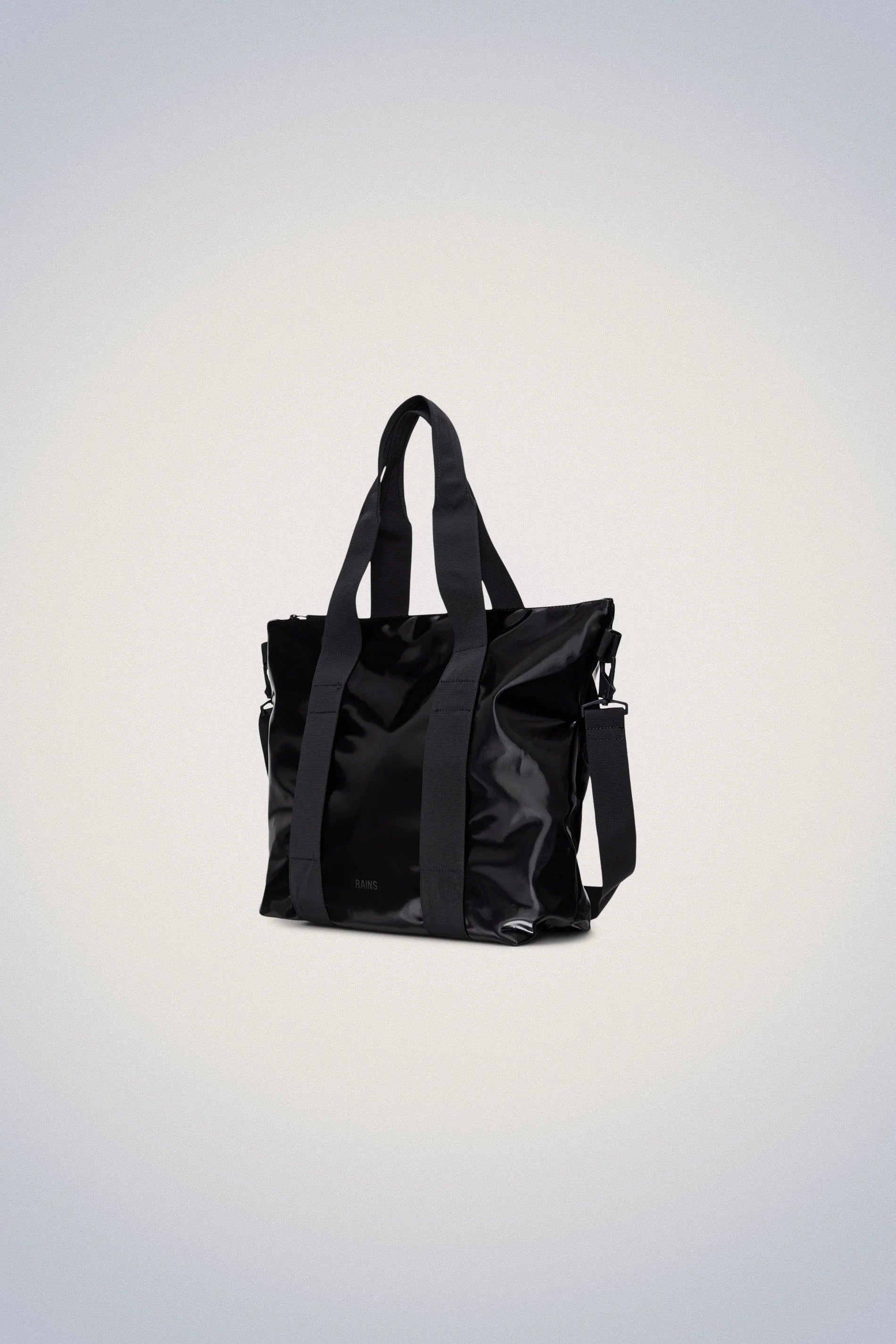 A Rains Tote Bag Mini - Night, with straps, featuring a magnetic closure and reinforced stitching for added durability.