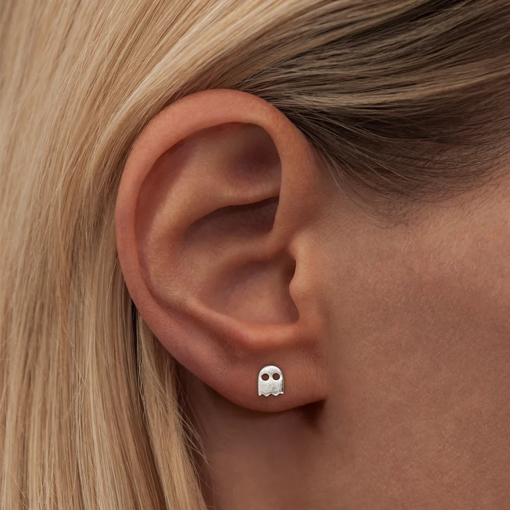 A woman's ear adorned with a Uhuu Single Stud earring from Lulu Copenhagen, evoking a playful and joyful spirit.