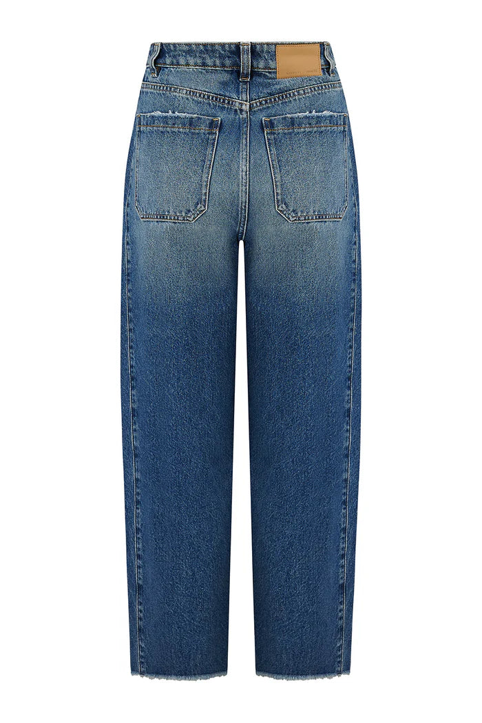A pair of Seventy & Mochi Bo Barrel Leg Jeans - Phoenix in super high-rise, straight-leg rigid denim with back pockets and a tan leather patch on the waistband, shown from the back.