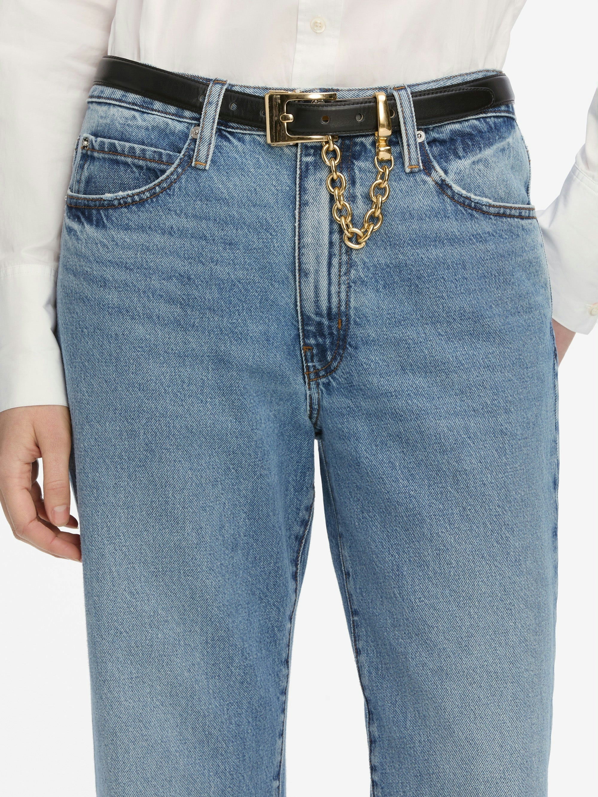 Blue jeans with a gold chain belt on a white background
