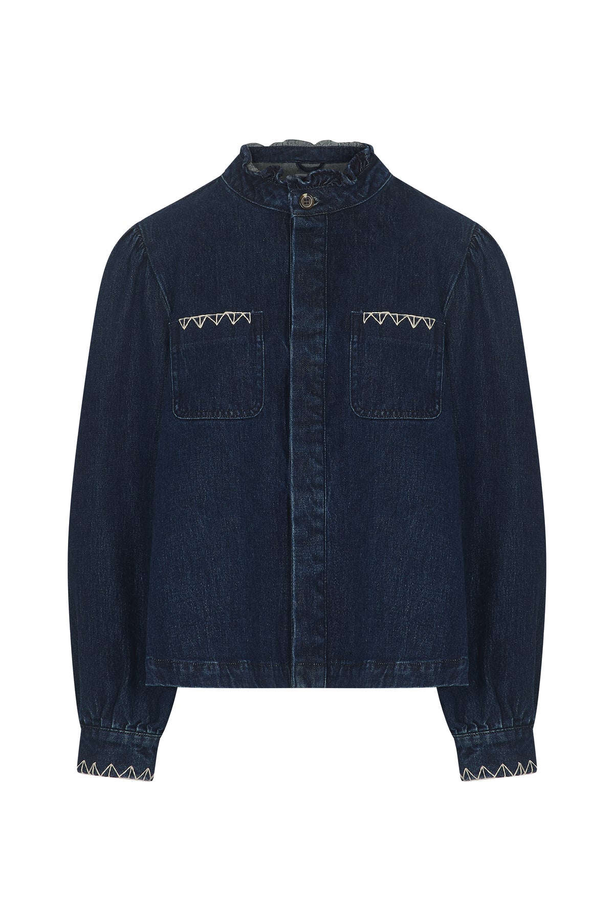 The Ziggy Jacket - Americana by Seventy & Mochi is a dark blue denim jacket crafted from organic cotton, featuring a relaxed fit with two front chest pockets, a buttoned collar, and distinctive white zigzag stitching on the pockets and cuffs.