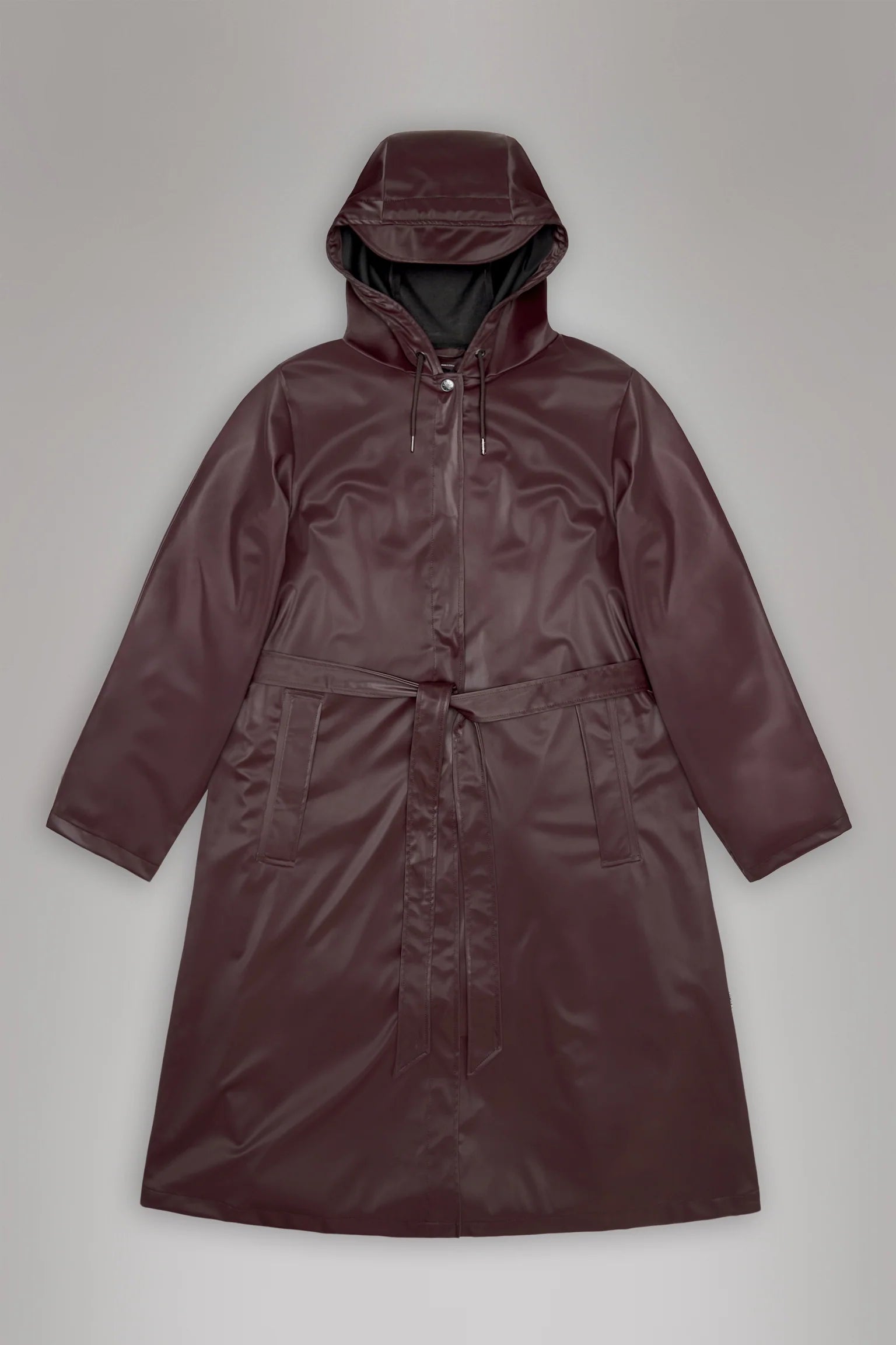 The Rains A-Line Longer W Jacket - Depth is a maroon women's raincoat with a hood, front zipper, drawstring, two front pockets, and a matching belt, shown flat on a neutral background.