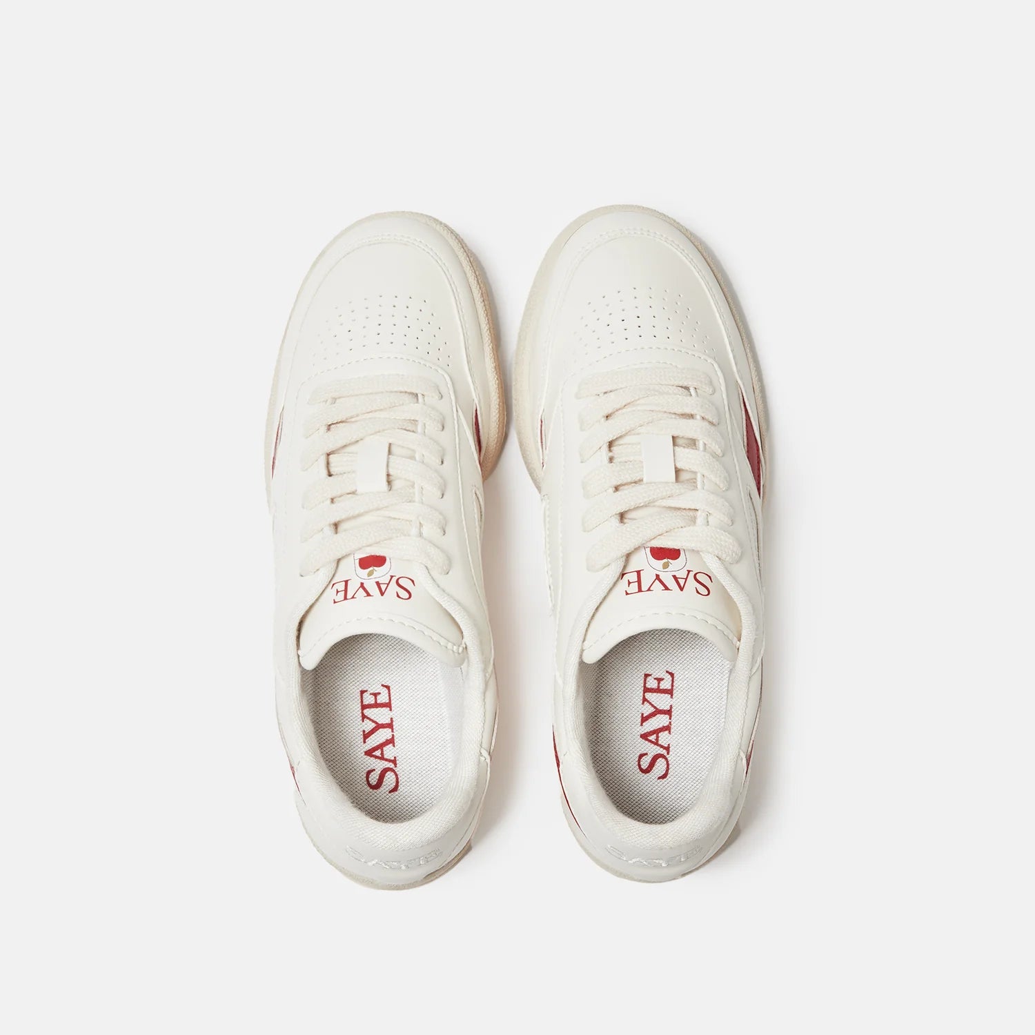 A pair of white Modelo '89 sneakers with Apple red letters on them. Brand Name: SAYE