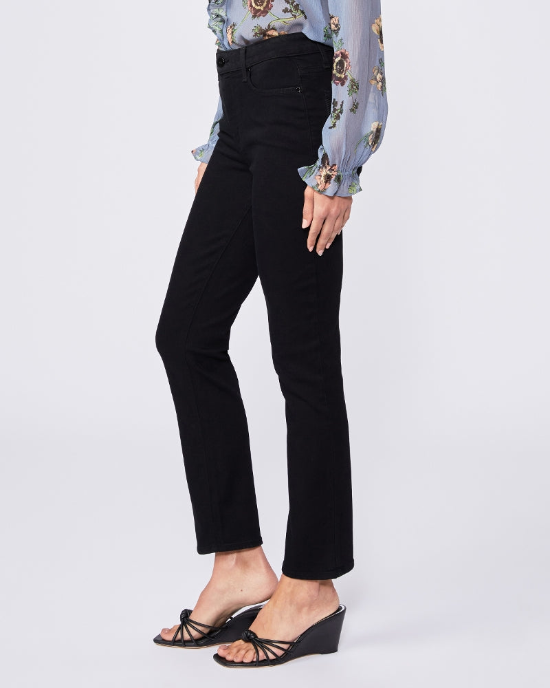 A woman wearing Paige super high rise black jeans and a floral blouse.
