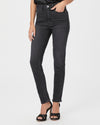 Model wears slim fitting straight leg jeans in a black wash colour. 