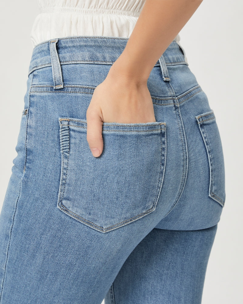 A person with a hand in the back pocket of Paige Cindy Straight Jeans in Golden Age denim.