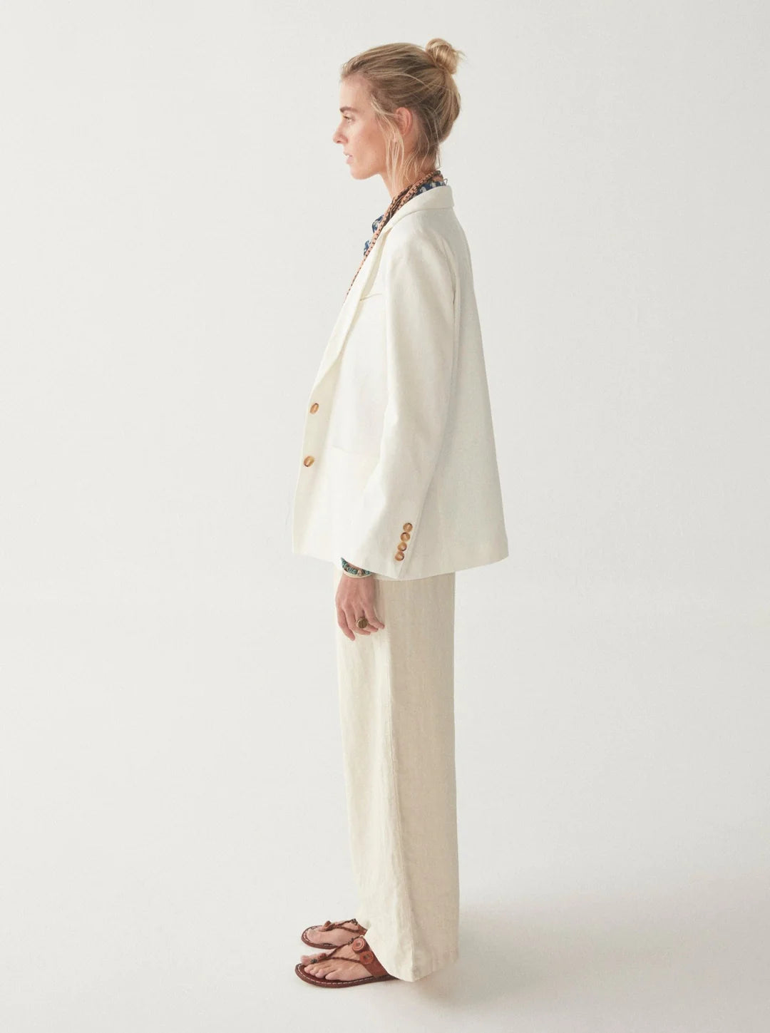 Model wears linen blazer jacket in white