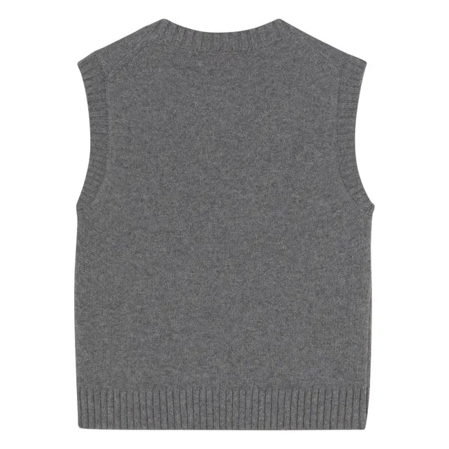The Buttoned Vest - Dark Grey by Tiny Big Sister is a sleeveless, ribbed-edge merino wool knit shown from the back, offering timeless style and soft comfort.