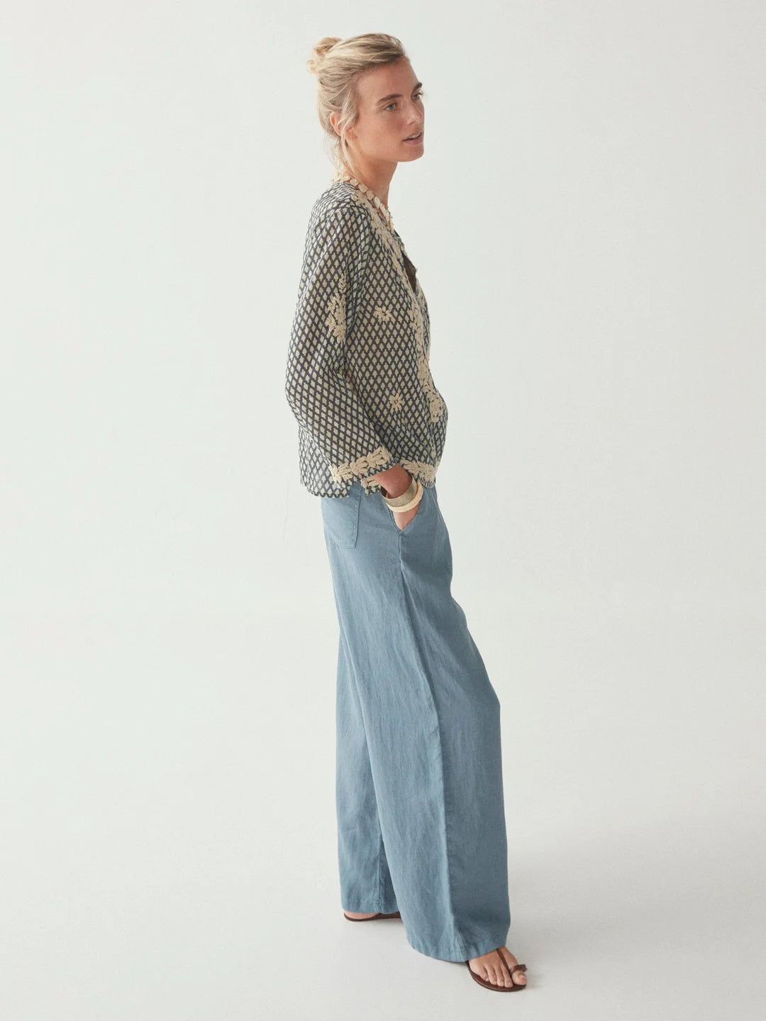 Model wears full length blue linen trousers