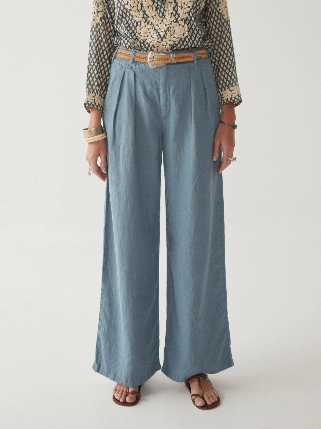 Model wears full length blue linen trousers