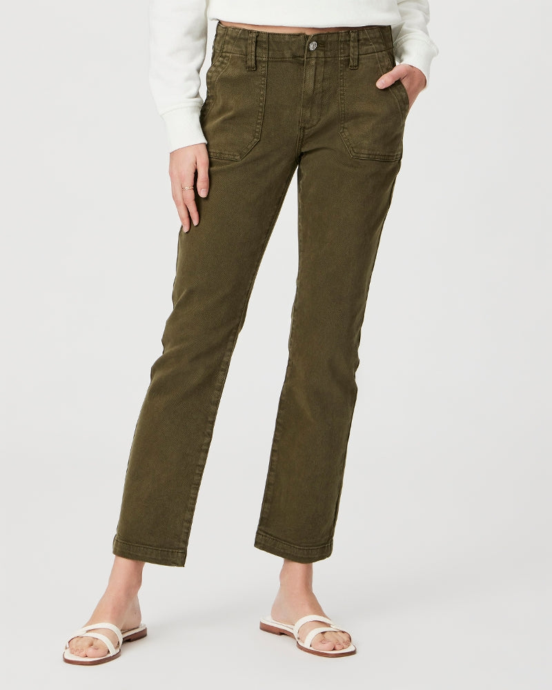 Woman wearing olive green, mid-rise Paige Mayslie Straight Ankle - Vintage Olive Meadow jean pants and white sandals.