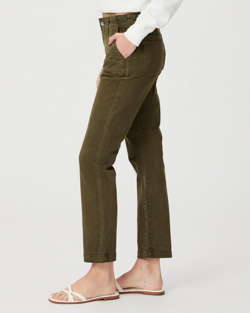 A person standing sideways wearing olive green Paige Mayslie Straight Ankle - Vintage Olive Meadow jean pants and white sandals.