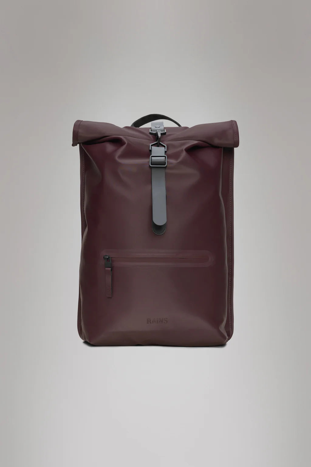 The Rains Rolltop Rucksack - Depth features a maroon color, black strap closure, front zipper pocket, and minimalist design. This waterproof backpack is ideal for daily bike commutes and is shown against a plain gray background.