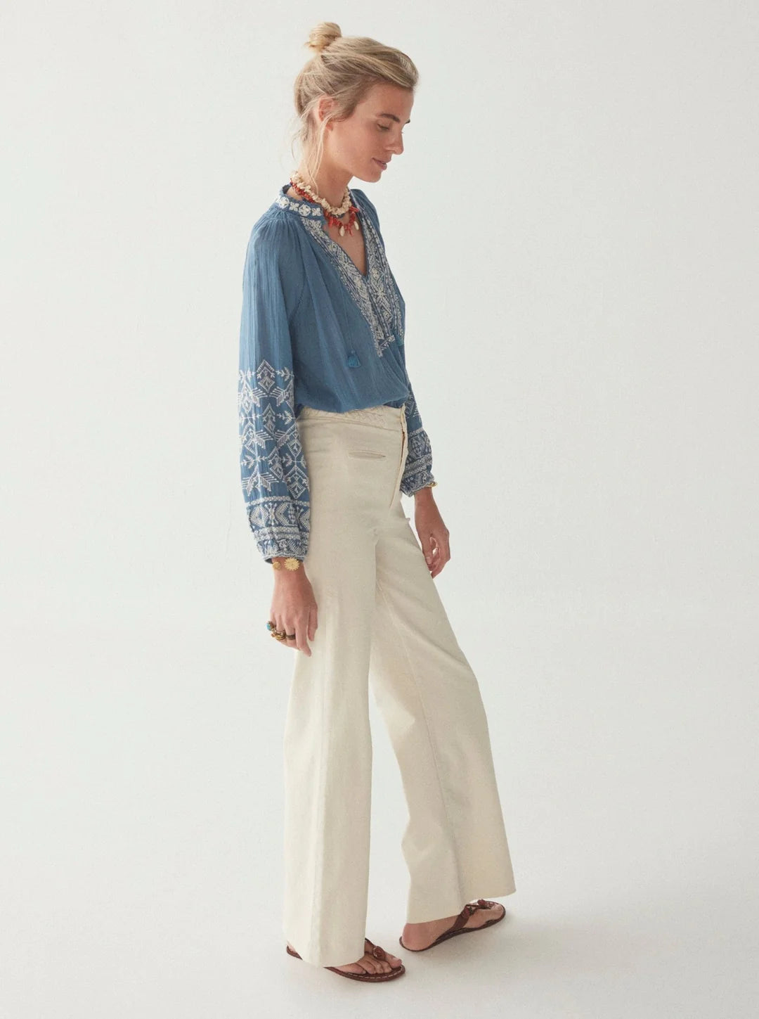 model wears blue blouse with off white embroidery