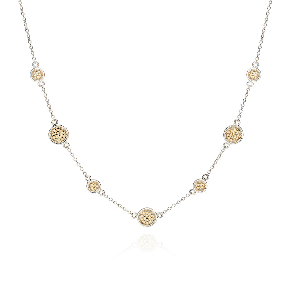 The Classic Station Necklace - Gold & Silver by Anna Beck features a handcrafted sterling silver chain, elegantly adorned with small, round 18k gold-plated pendants spaced evenly throughout its sophisticated design.