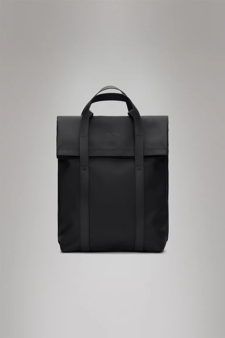 The Rains 2 Way Tote Backpack - Black is a square-shaped commuter bag with a top handle, two front straps, and a fold-over flap, shown against a plain gray background.
