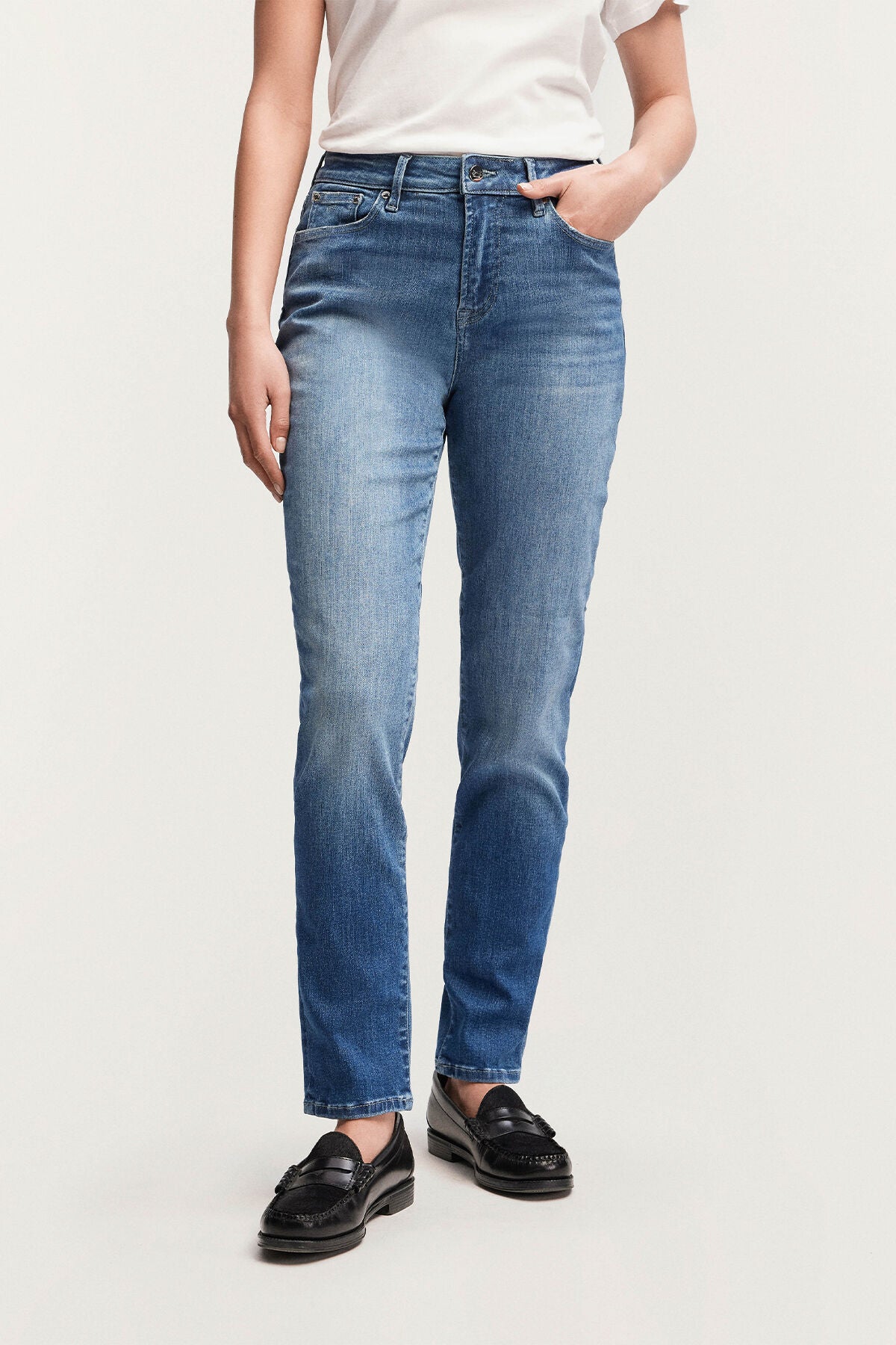 A woman wearing Denham MARGOT High Slim - Light Worn Indigo blue jeans.