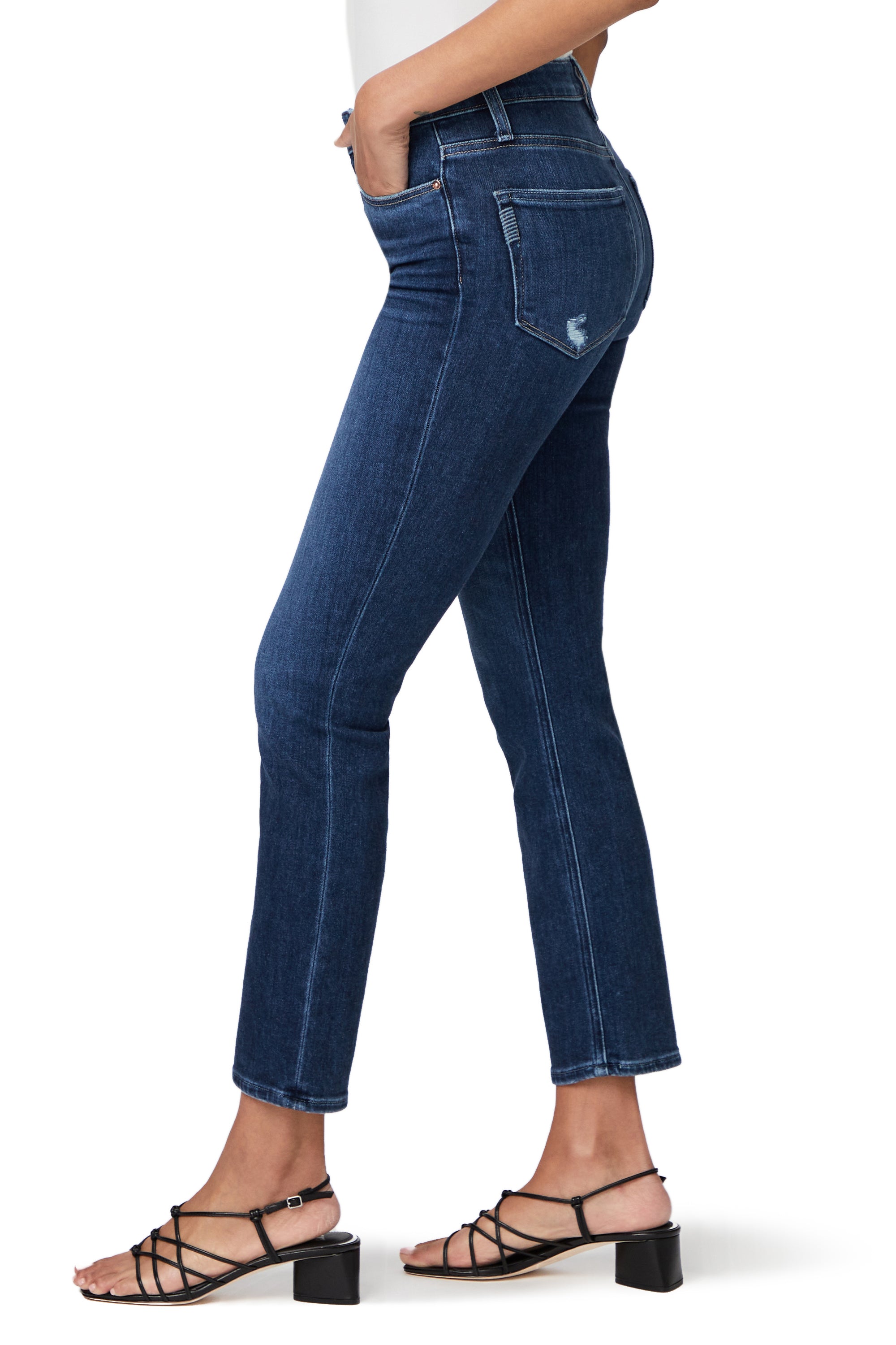 The back view of a woman wearing Paige high rise vintage denim jeans in a medium blue wash, the Cindy Straight Ankle - Emotion Distressed.