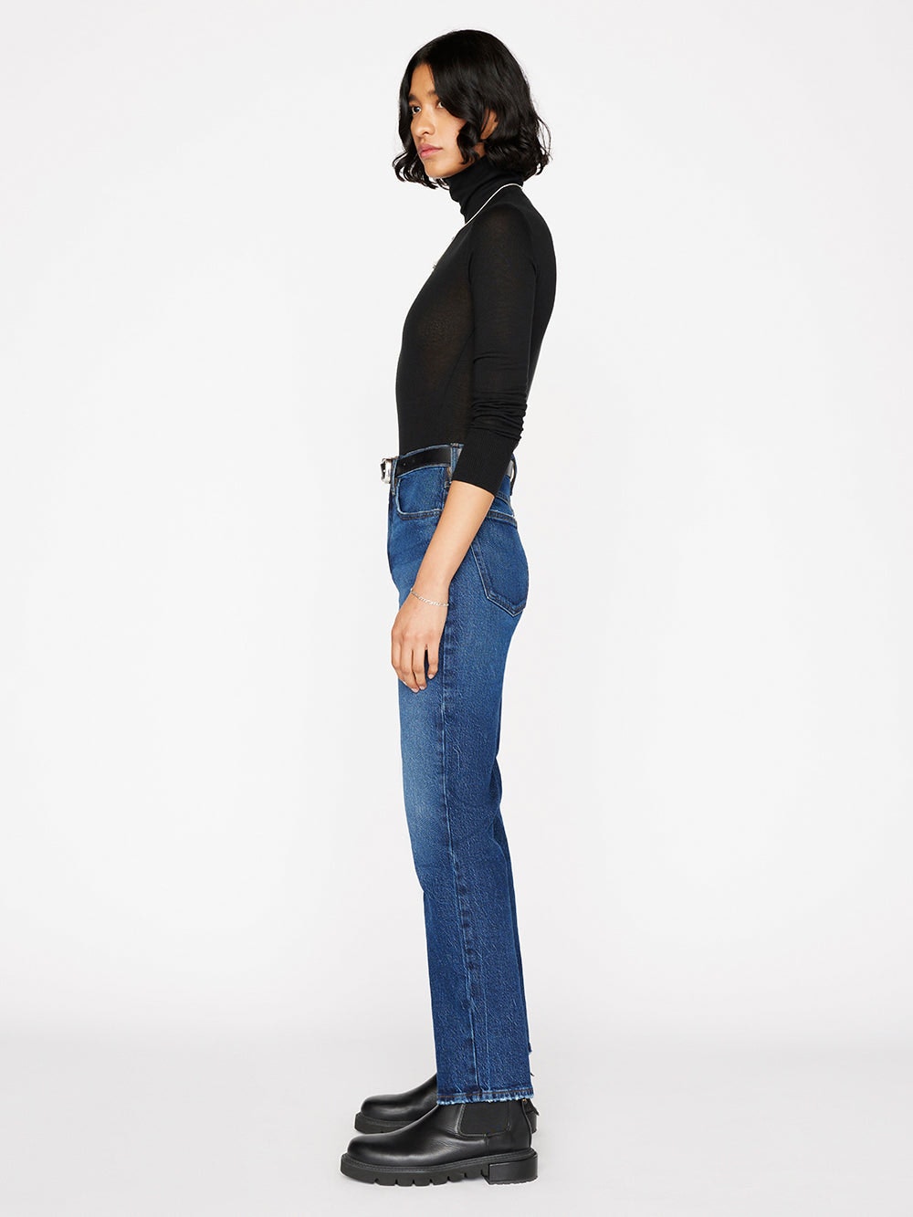 A woman wearing the Frame Le High 'N' Tight Straight - Hallam jeans and a turtle neck.