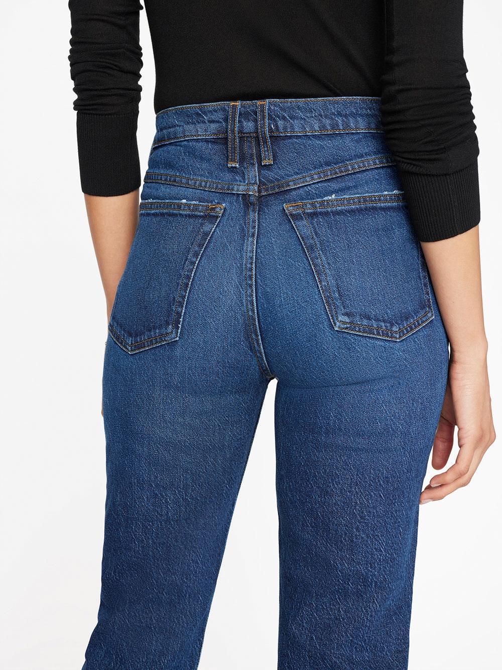 The back view of a woman in Frame Le High 'N' Tight Straight - Hallam denim jeans.