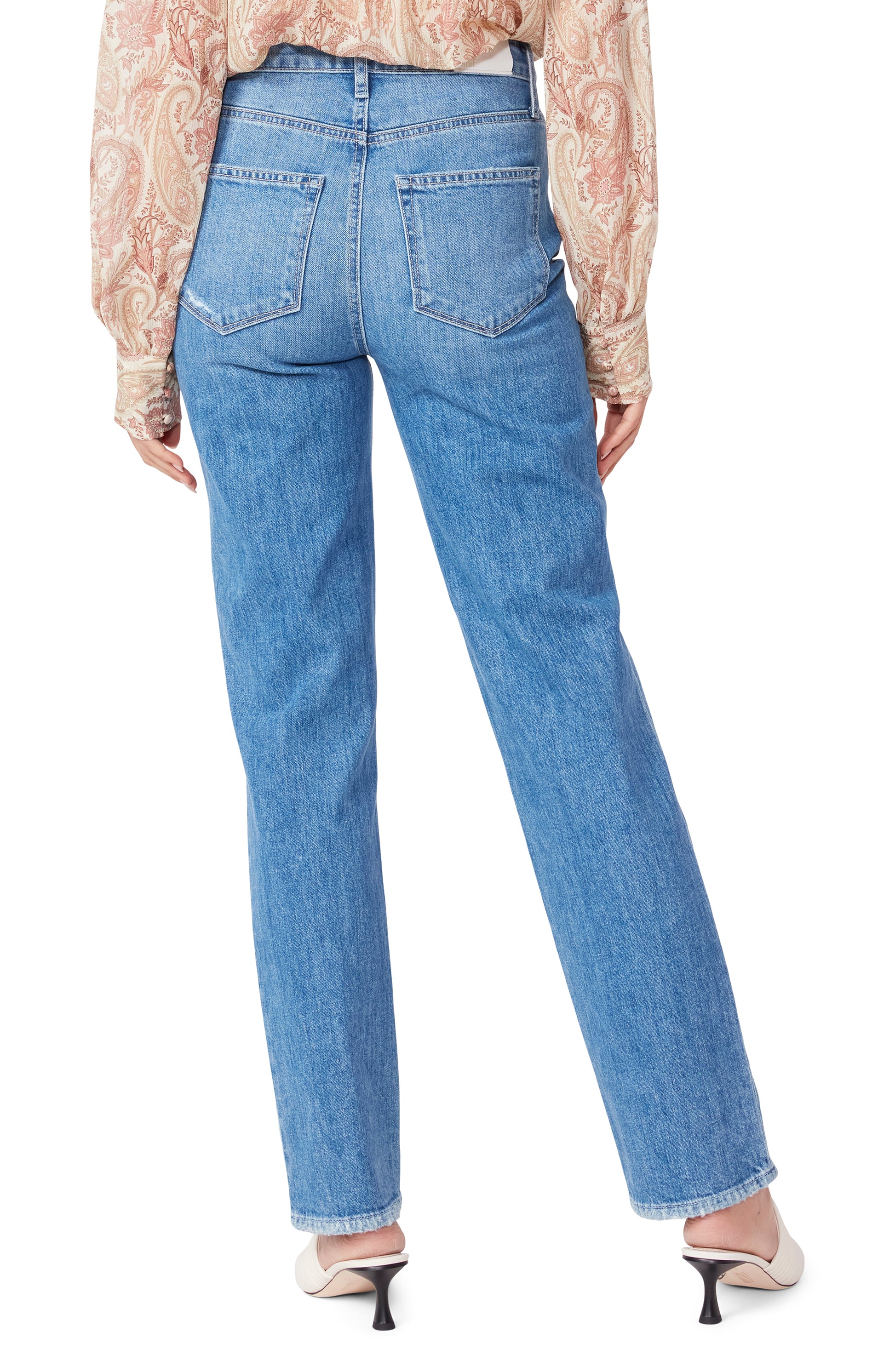 The back view of a woman wearing Paige Sarah Straight 30" - Wannabe Distressed flared jeans.