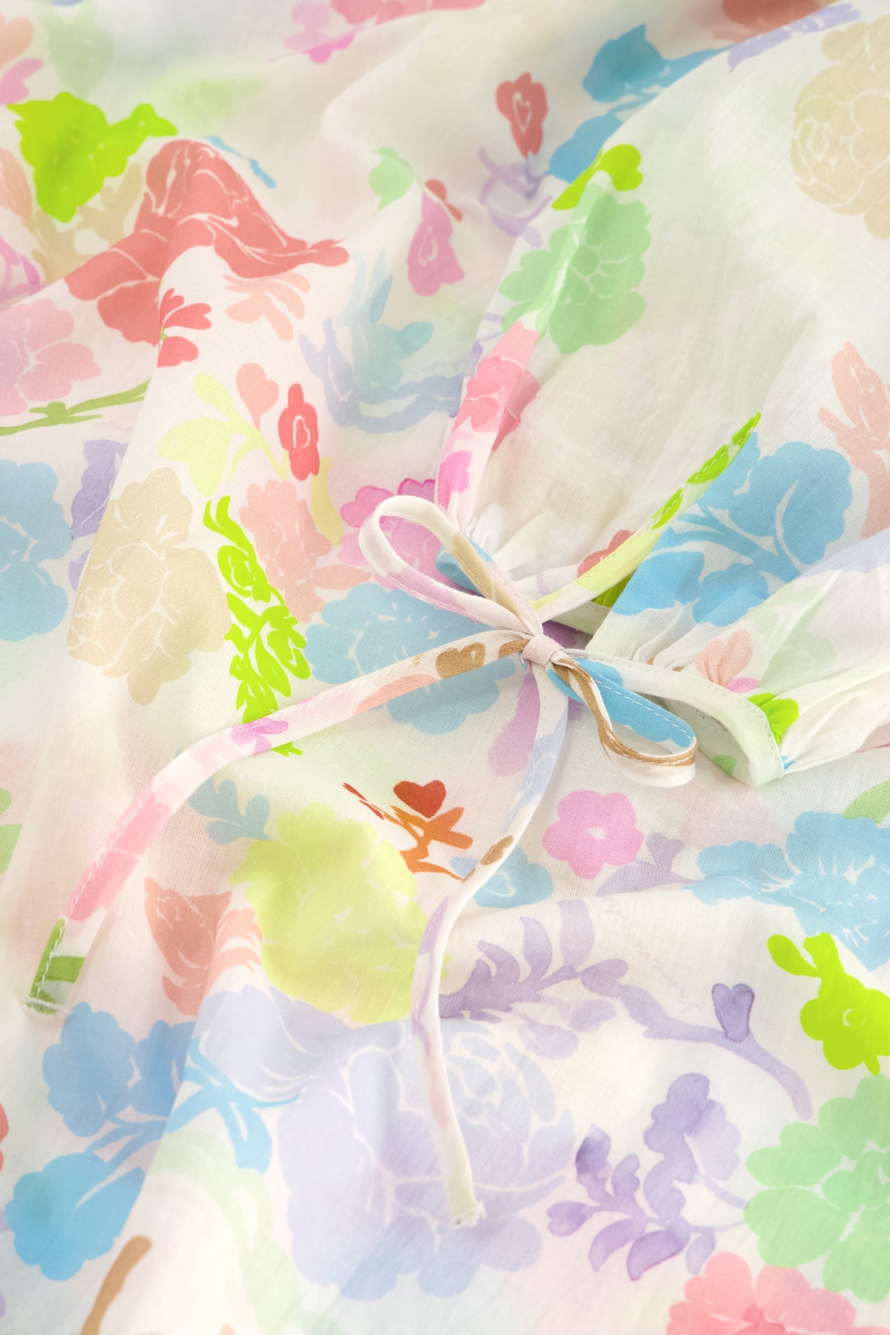 Description: A close up of a flower printed Dover Dress - Caribbean Mini made from organic cotton by Fabienne Chapot.