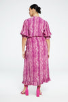 person wears Fabienne Chapot Channa dress in snake print styles with pink hig heeled sandals, against a white backdrop
