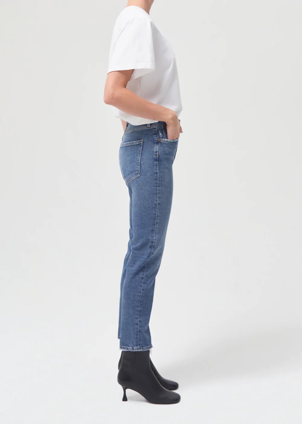 The back view of a woman wearing AGOLDE's Riley Straight Crop - Silence denim jeans and a white t-shirt.