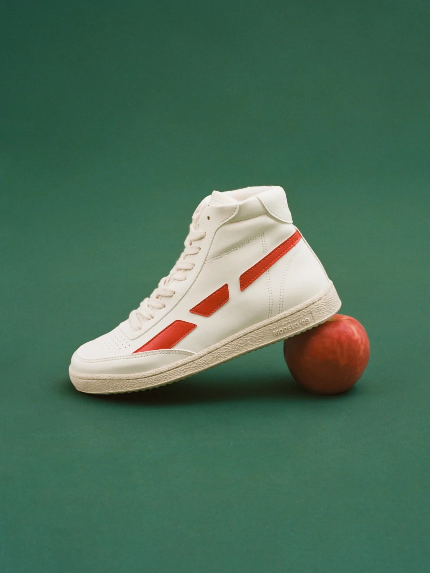 A white high top sneaker with vegan leather on top of a SAYE Modelo '89 Hi Sneakers - Apple.