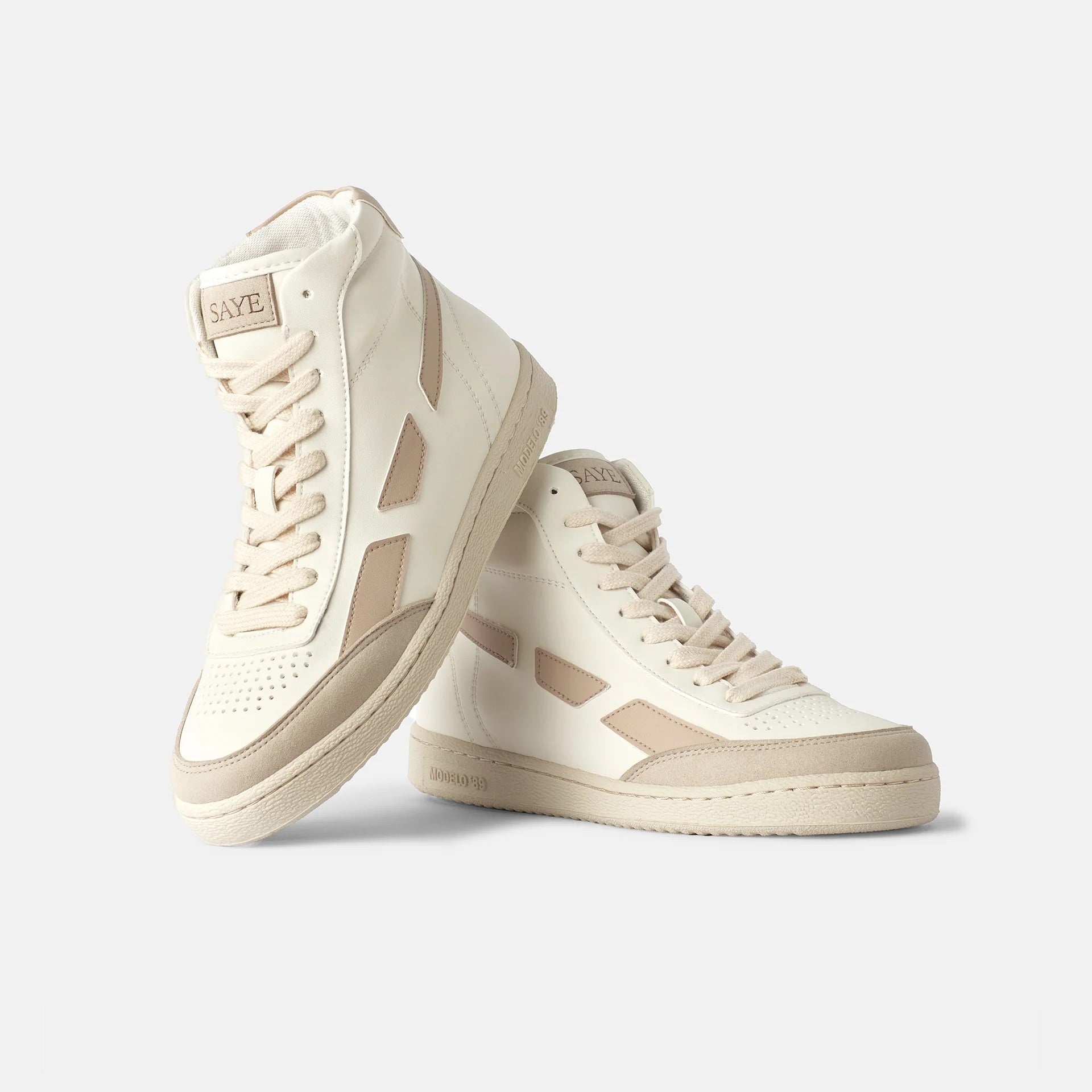 A pair of high top Modelo '89 Hi sneakers in beige and tan, featuring bamboo lining and bio-based vegan leather. Brand name: SAYE.