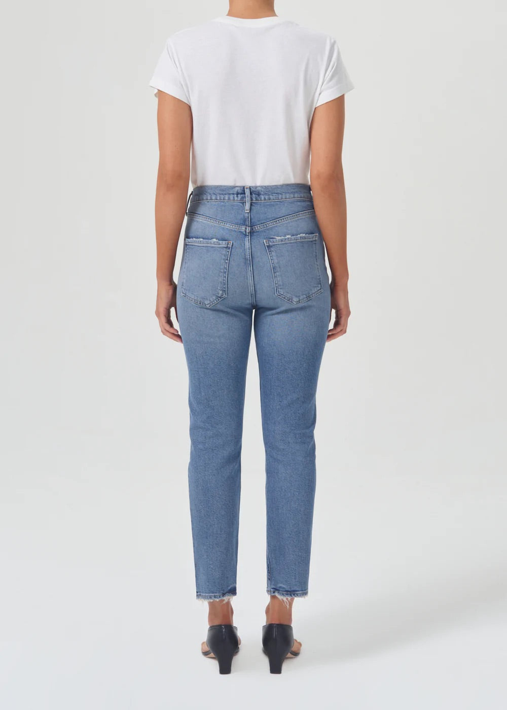 The back view of a woman wearing an AGOLDE Riley Straight Crop - Cove white t-shirt and straight leg jeans.
