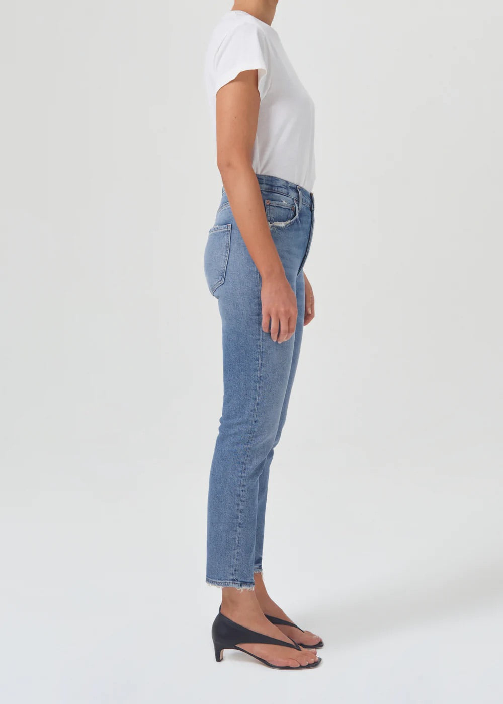 The front view of a woman wearing the AGOLDE Riley Straight Crop - Cove and jeans made from organic cotton.