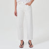 lower body wears white straight leg agolde jeans with black sandals against a white studio backdrop