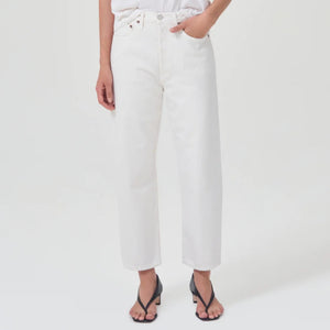 lower body wears white straight leg agolde jeans with black sandals against a white studio backdrop