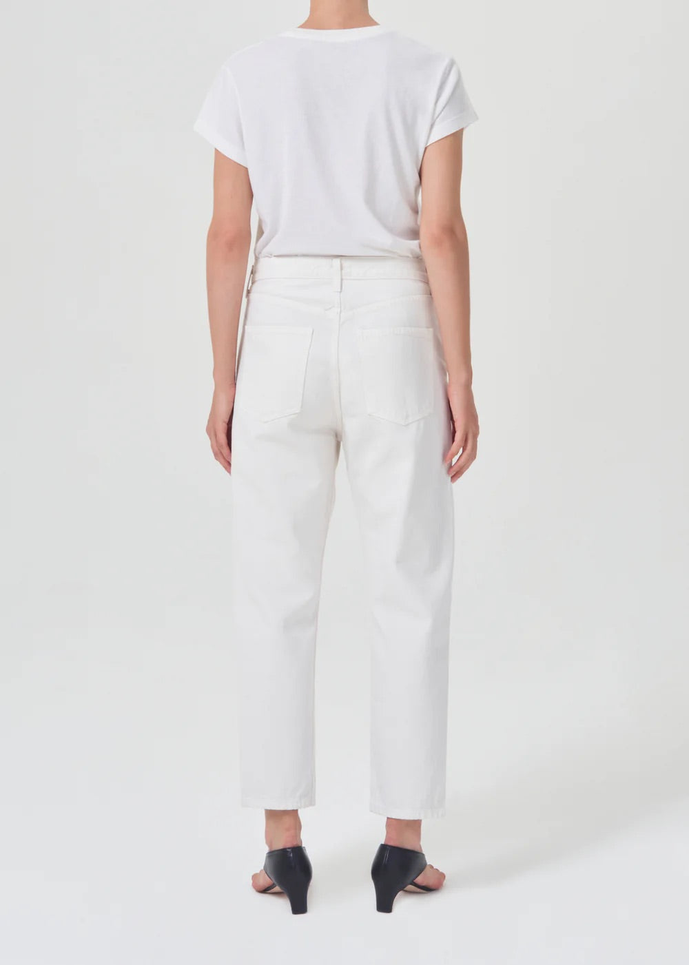 The back view of a woman wearing AGOLDE 90's Straight Crop - Salt jeans and a relaxed fit white t-shirt.