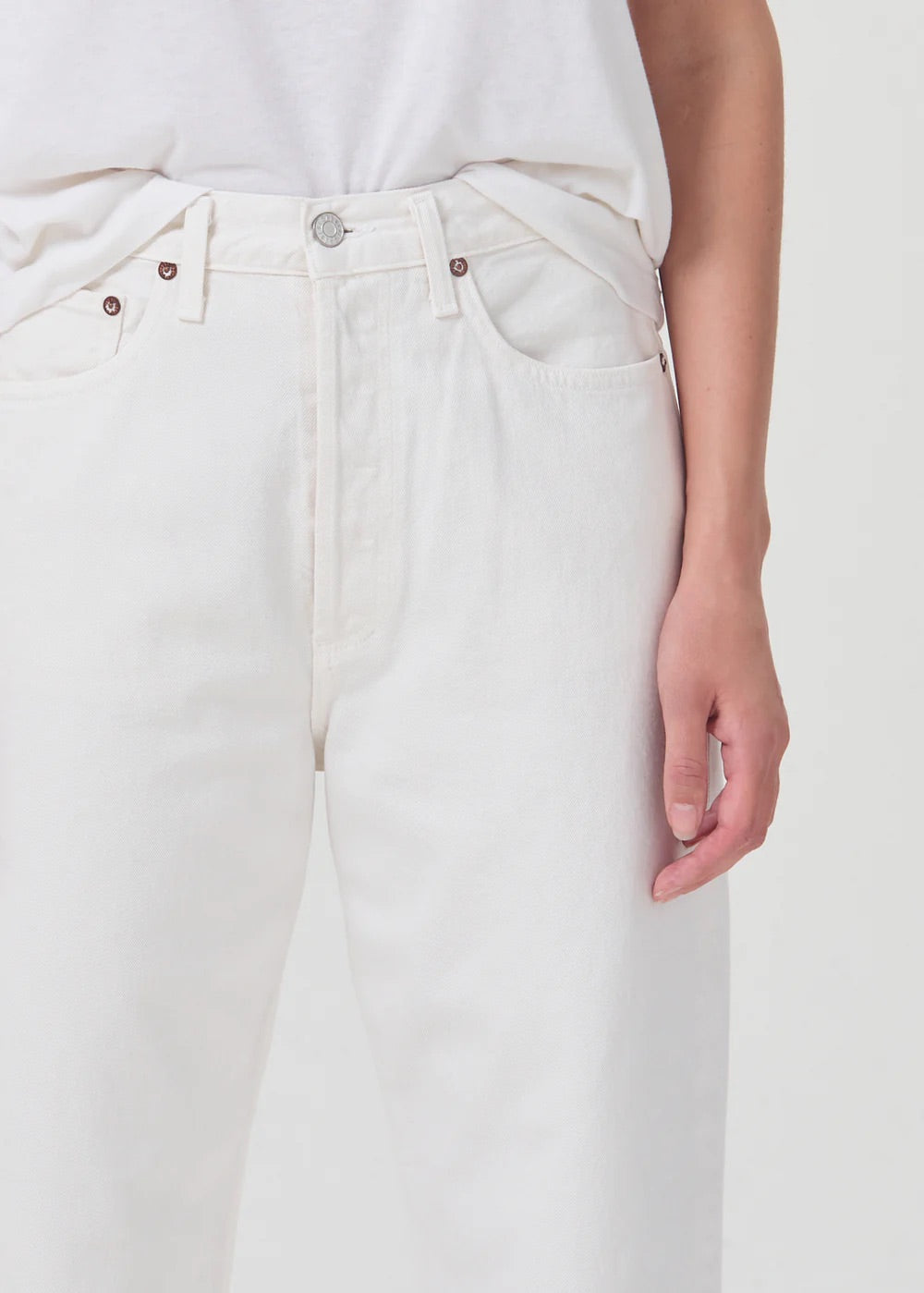 A woman wearing the AGOLDE 90's Straight Crop - Salt jeans, a relaxed fit white t-shirt.