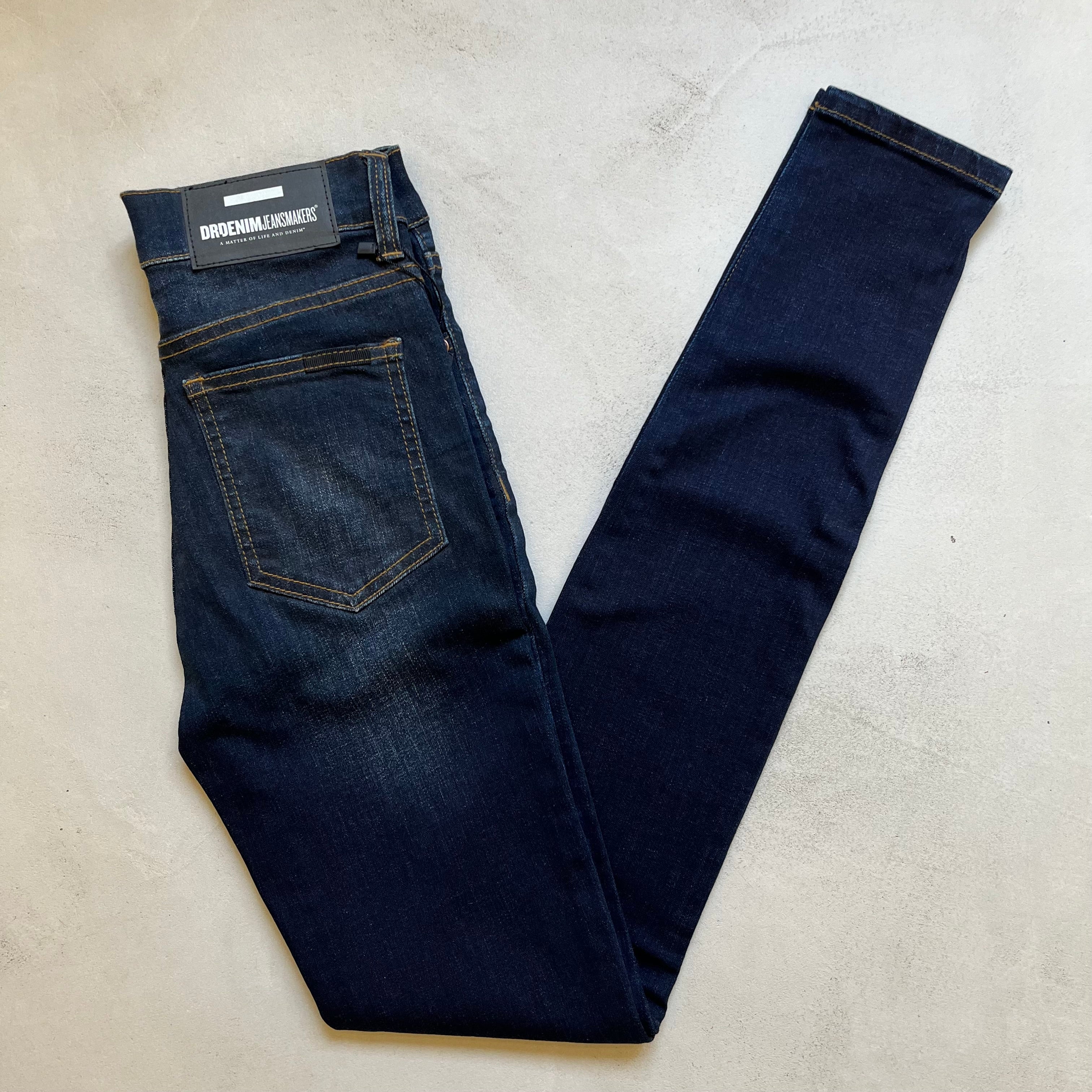 A pair of Dr Denim Regina - Dark Blue mid-weight stretch denim skinny jeans on a white surface.