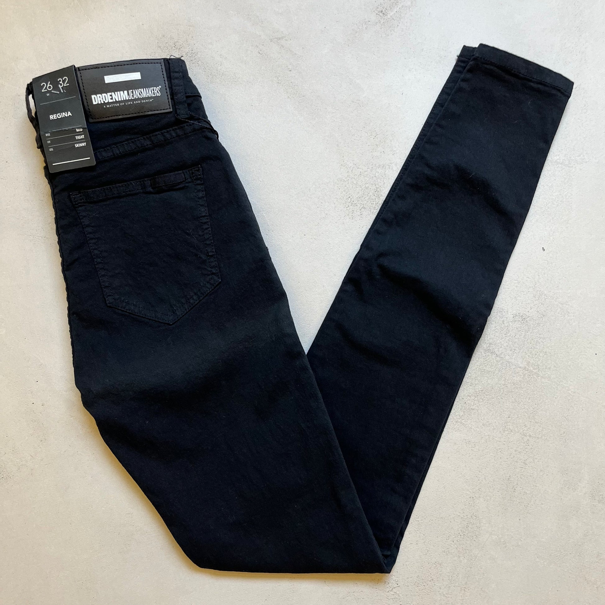 A pair of Dr Denim Regina - Black super stretch denim black jeans with a tag on them, perfect for Regina's skinny jean style.