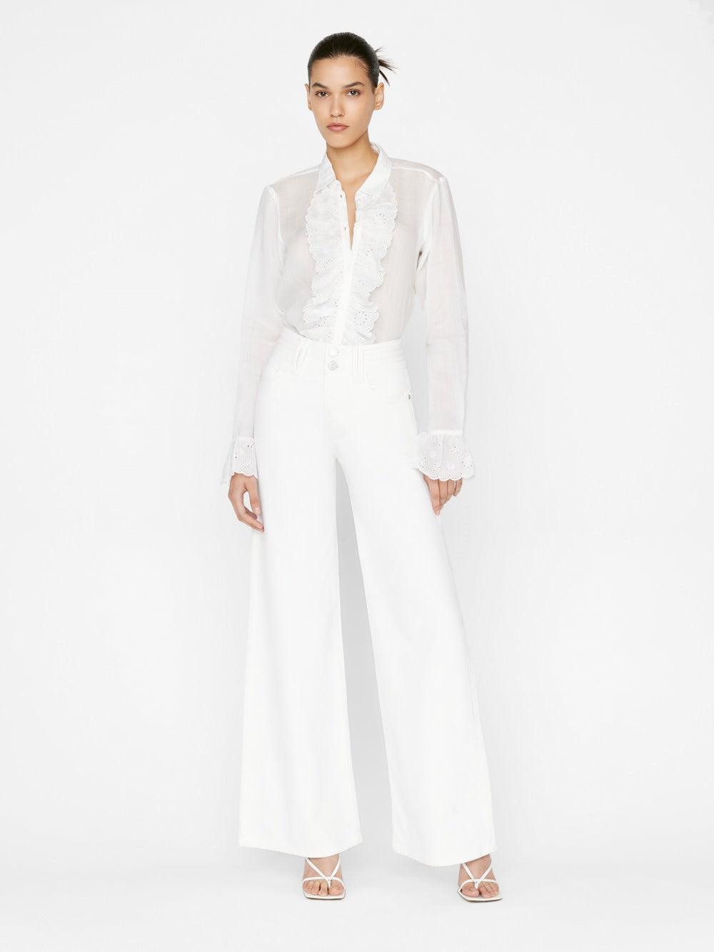 The model is wearing a Frame Triple Stitch Wide Leg - Blanc blouse and high-rise wide-leg pants.