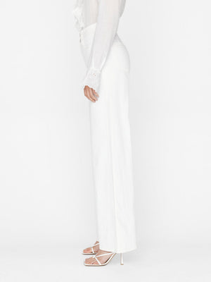 Woman wears triple wide leg by frame in bright white