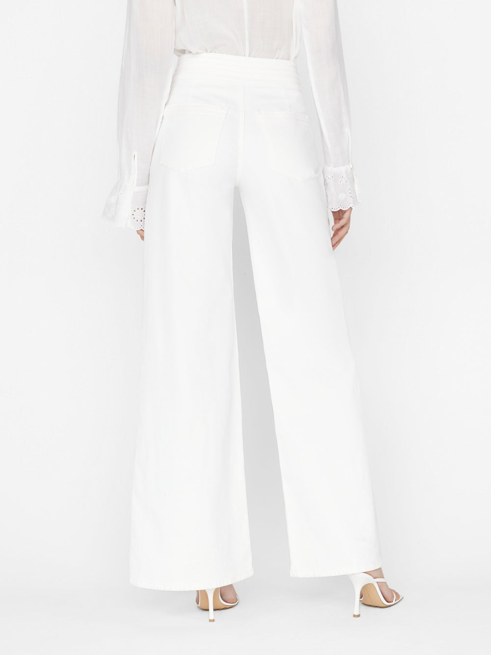 The back view of a woman wearing Frame's Triple Stitch Wide Leg - Blanc in white.