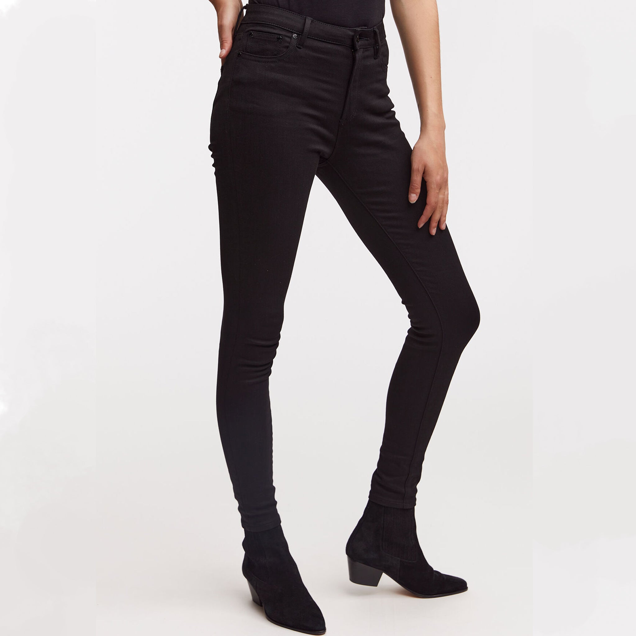 A woman wearing NEEDLE Skinny - True Black denim jeans by Denham and an indigo denim top.