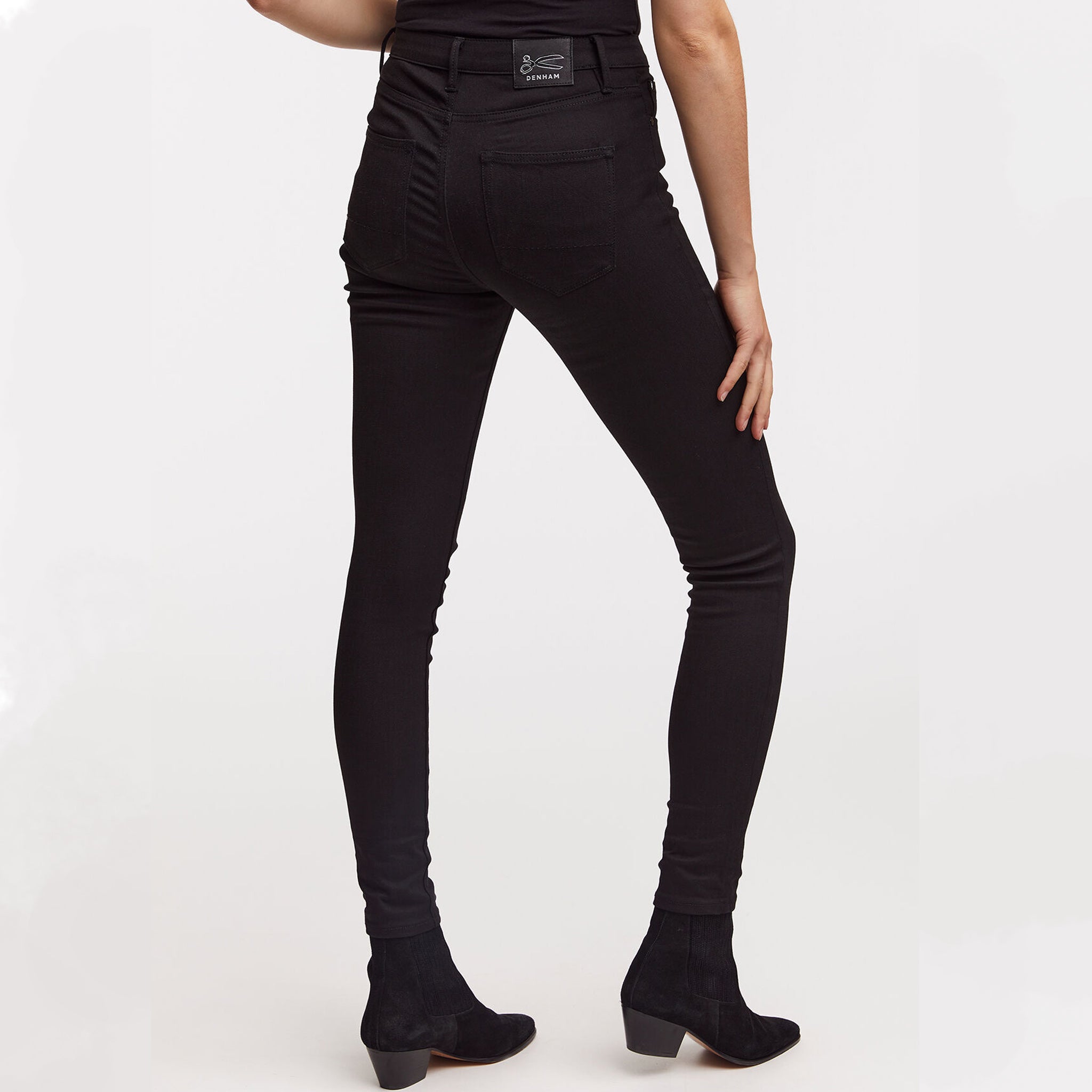 The back view of a woman wearing Denham's NEEDLE Skinny - True Black jeans.