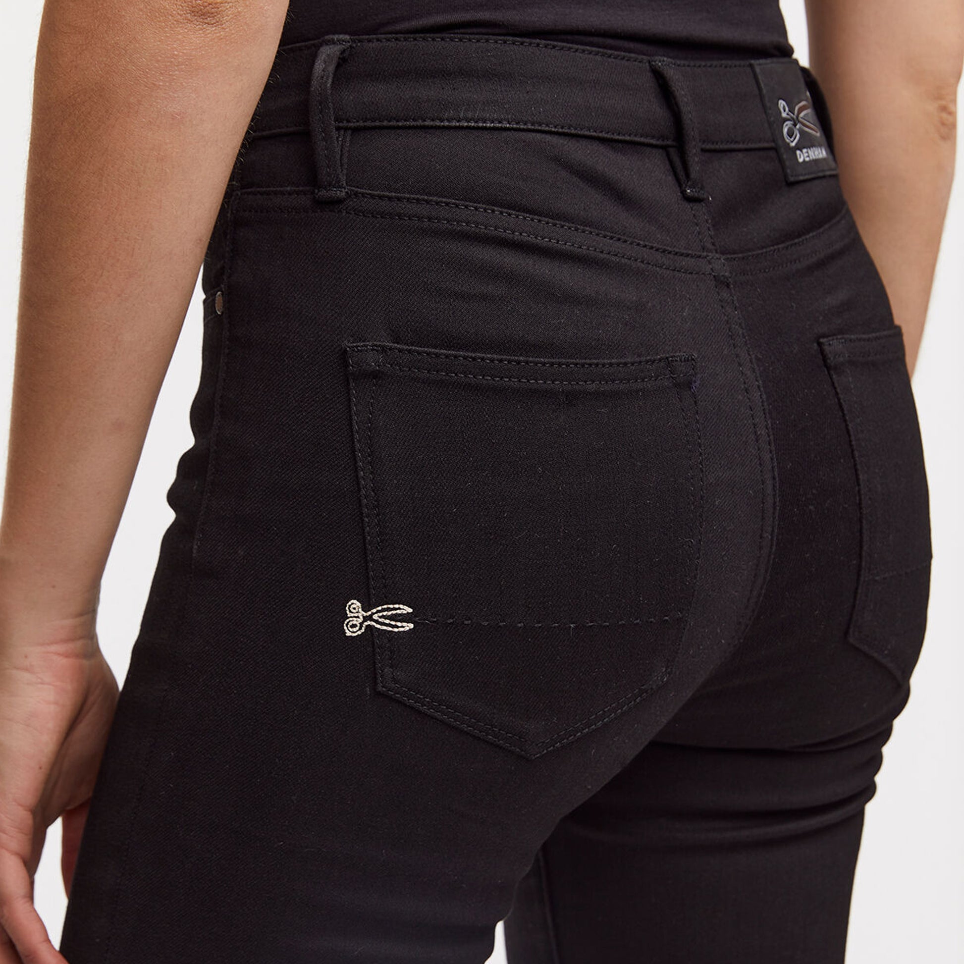 The back view of a woman wearing Denham NEEDLE Skinny - True Black denim jeans.