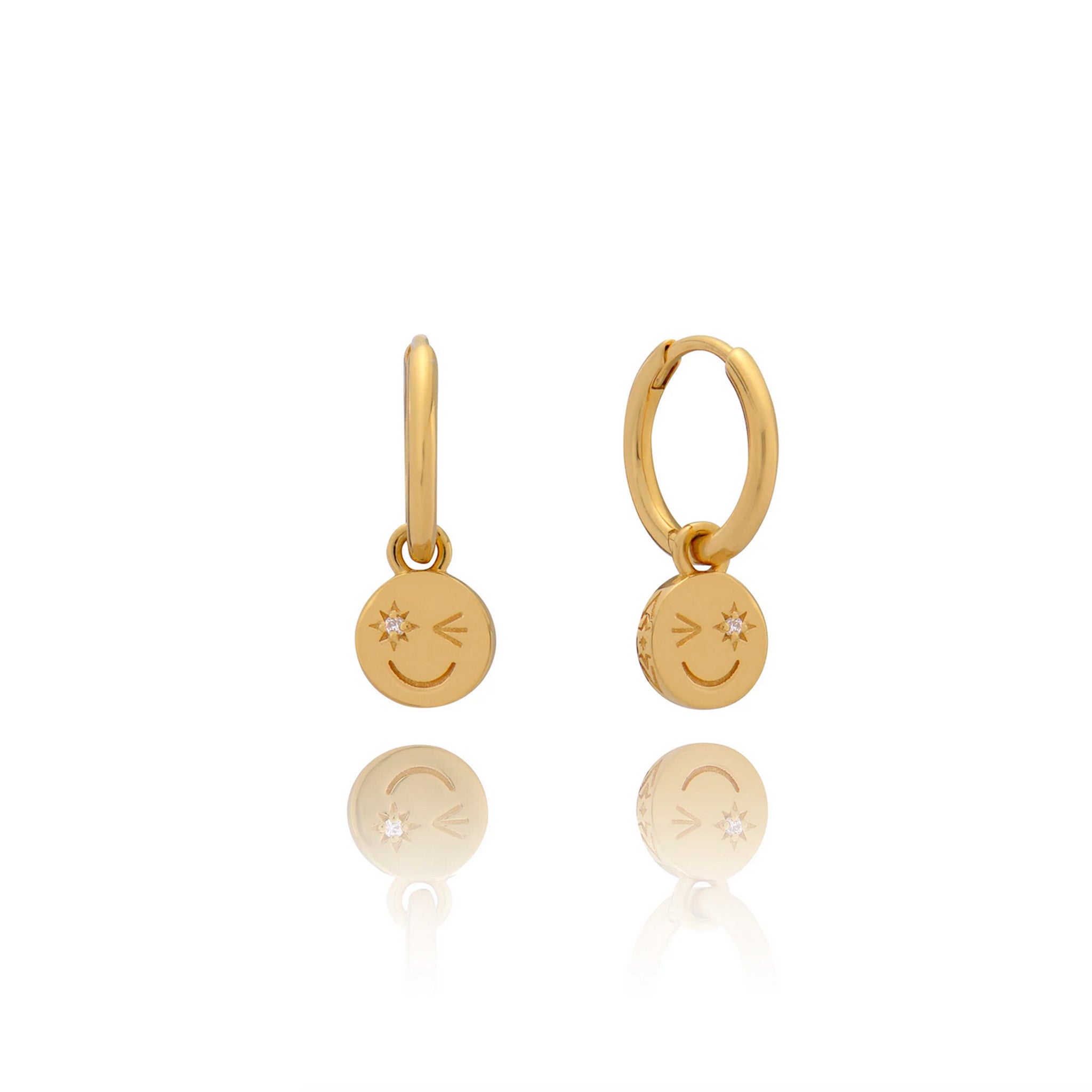 A pair of Happy Face Huggie Hoop Earrings - Gold by Rachel Jackson with a smiley face.