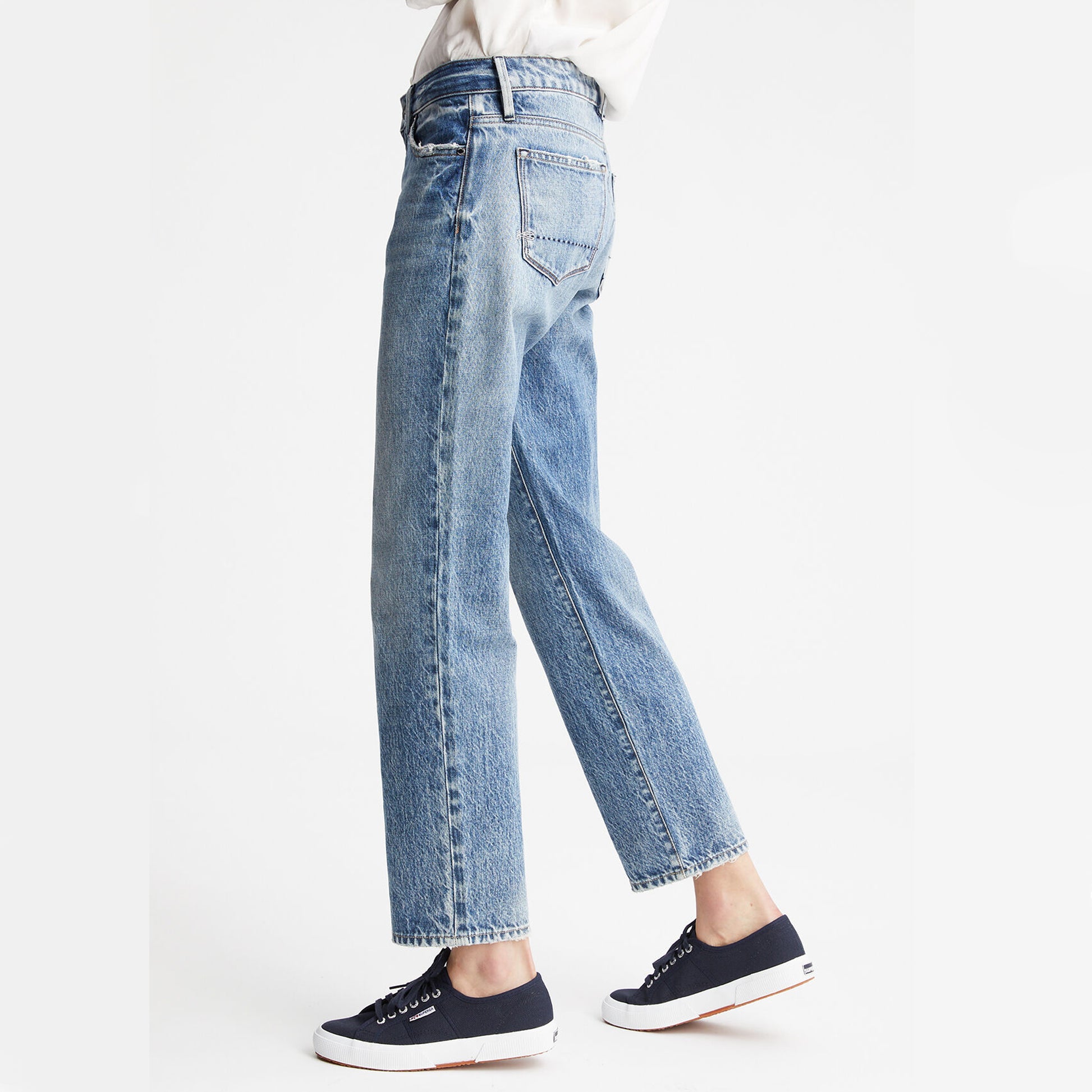 The back view of a woman wearing a pair of Denham BARDOT Straight Leg - Stonewash Blue jeans made from organic cotton using a sustainable process.