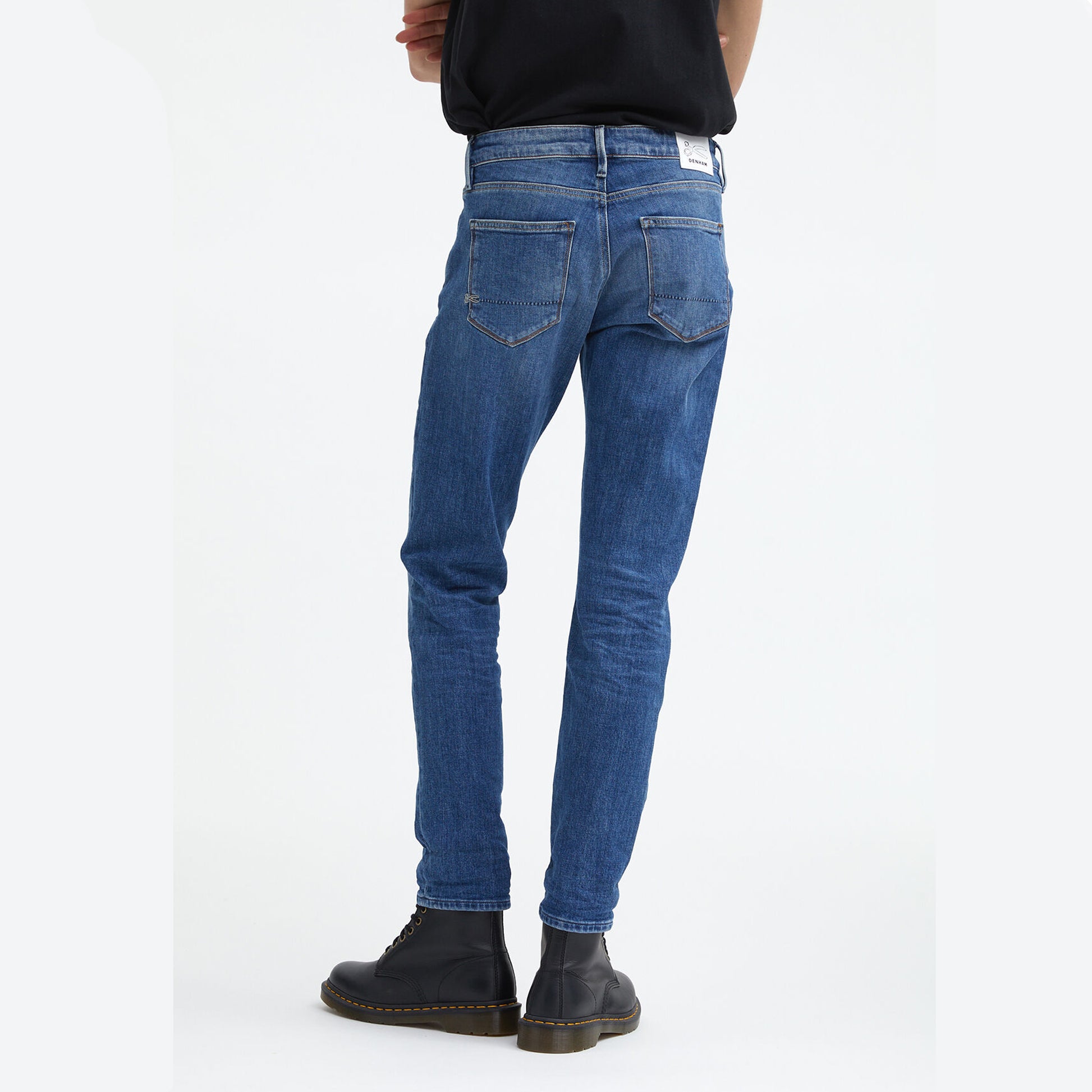 The back view of a man wearing Denham's MONROE Mid Girlfriend - Light Fade & Whiskers blue jeans.