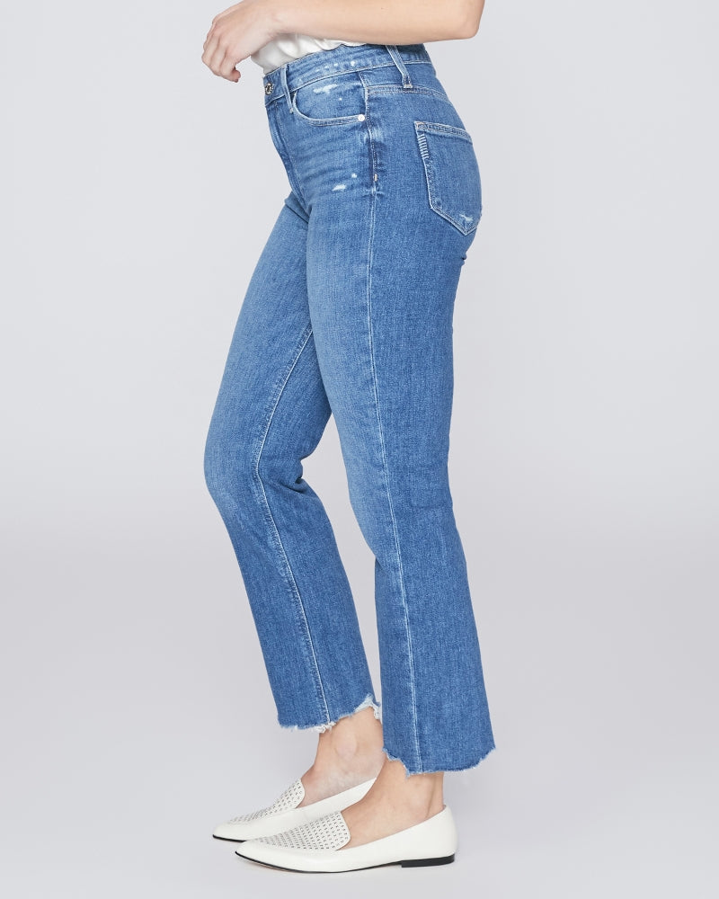 The back view of a woman wearing a pair of Sarah Straight Crop - Love Letter Distressed high-waisted denim flared jeans by Paige Vintage.